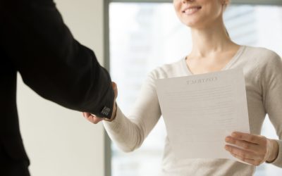 Female business leader holding contract document and shaking hand with colleague before or after negotiation. Businesswoman concluding agreement, starting partnership, accepting offer. Close up view
